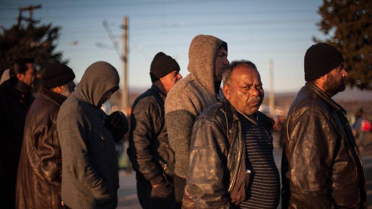 Flüchtlinge stehen vor den Sanitäranlagen im Lager Idomeni an.