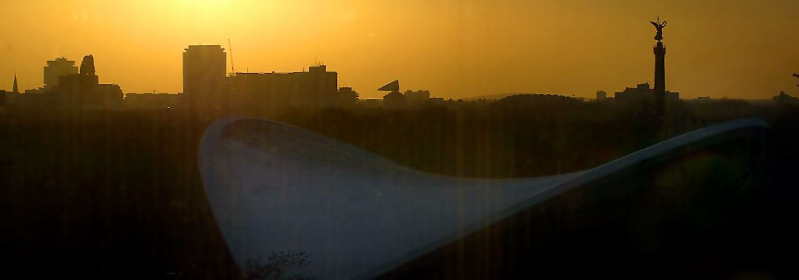 Sonnenuntergang über der westlichen City Berlins: Kaiser-Wilhelm-Gedächtniskirche, Kranzlerpassage, Kantdreieck und Siegessäule (v.l.), im Vordergrund das Dach des Hauses der Kulturen der Welt.