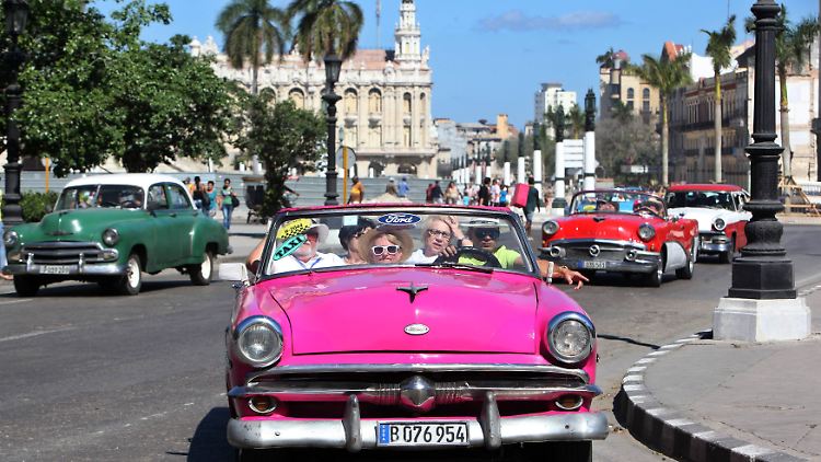 Klassiker: Touristen fahren in einem Oldtimer durch Havanna.