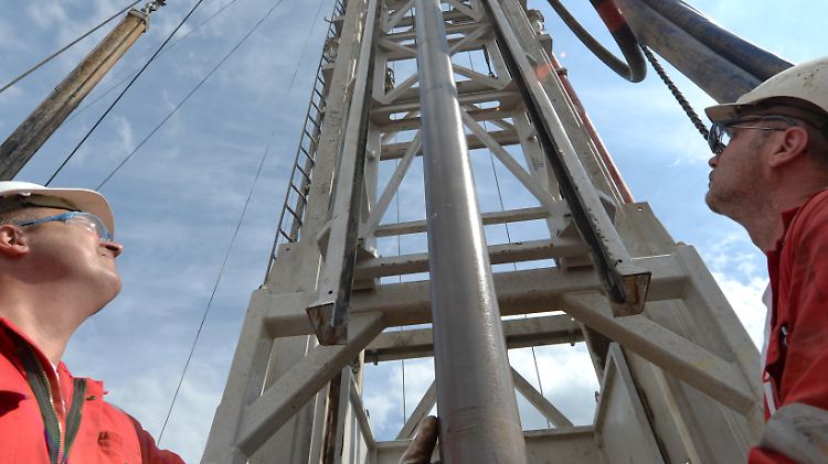 Zwei Bohrarbeiter stehen in Crumstadt (Hessen) auf der Arbeitsbühne der Bohranlage von Rhein Petroleum am Bohrgestänge.