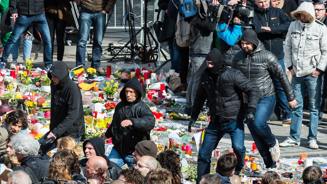 Die rechten Demonstranten laufen über Blumen und andere Gegenstände, die am Place de la Bourse in Gedenken an die Opfer niedergelegt wurden.