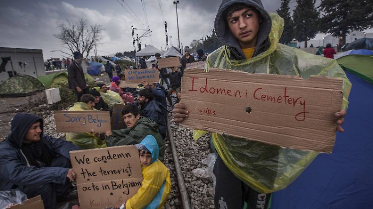"Friedhof Idomeni" und "Wir verurteilen die Anschläge in Belgien" steht auf den Schildern der Flüchtlinge. 