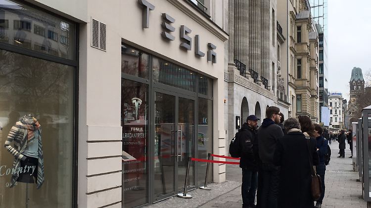 Mit der Zeit versammeln sich immer mehr Kaufwillige vor dem Tesla-Store am Kudamm in Berlin.