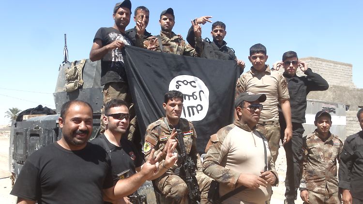 Ein Symbol für die teilweise Rückeroberung der Stadt Heet: Irakische Soldaten zeigen die abgenommene IS-Flagge.
