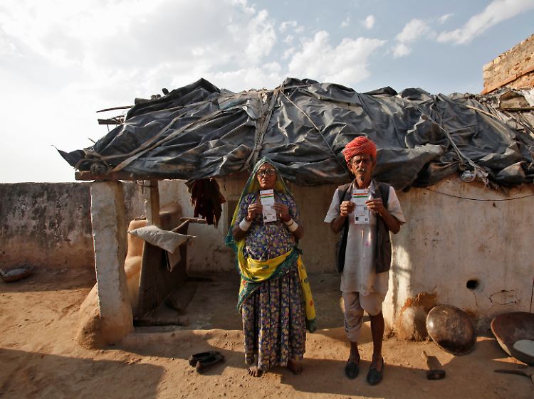 Biometrisch erfasste Bürger: Champa Devi (l.) und ihr Mann Ghewar Ram halten ihren neuen Aadhaar-Ausweis in die Kamera.