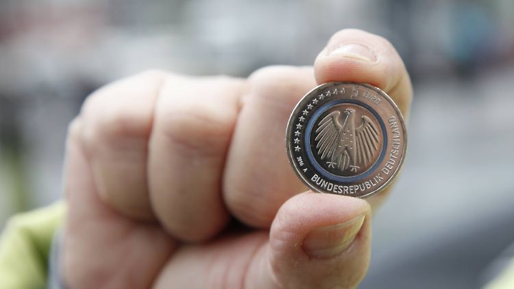 Da hat es jemand geschafft - und hält die neue Fünf-Euro-Münze in der Hand.