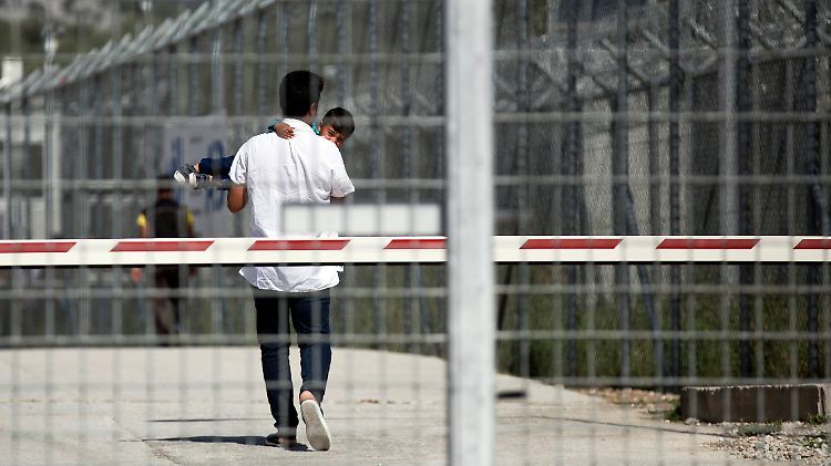 Ein Mann und sein Kind warten in einem Lager auf Lesbos auf ihre Rückführung in die Türkei.