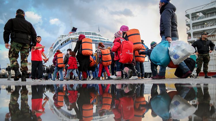 Die Hafenpolizei begleitet Flüchtlinge auf Lesbos zur Fähre nach Piräus.