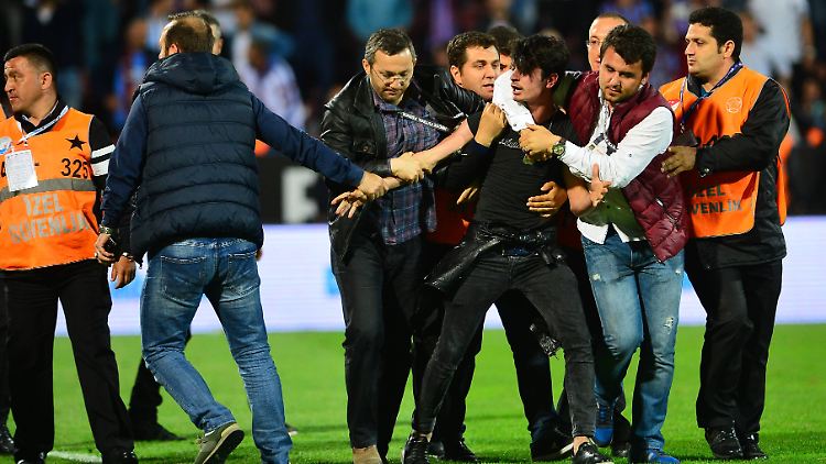 Spielabbruch in Istanbul: Die Ordner kümmern sich um den Mann, der auf den Torraumrichter eingeschlagen hat.