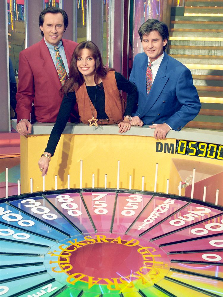 Früher drehte sich das "Glücksrad" mit Peter Bond (l.), Frederic Meisner und Buchstabenfee Maren Gilzer bei Sat.1 - jetzt bei RTLplus.