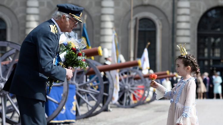 Der schwedische Monarch nimmt im Innenhof des Schlosses Blumen von Kindern entgegen.