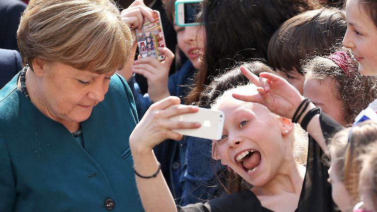 In einigen Dingen ähneln sich Merkels Schulbesuche sehr: Selfies, Autogramme und Applaus.