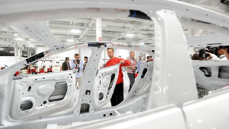Ein Arbeiter kontrolliert die Lackierung bei einem Tesla Modell S.