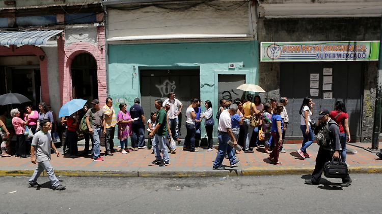 Menschen stehen in Caracas Schlange, um Lebensmittel zu kaufen. 