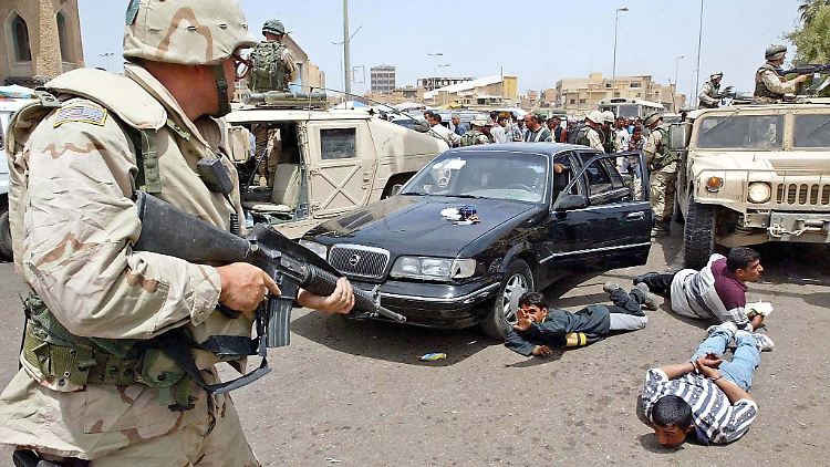 Ein US-Militärpolizist stellt in Bagdad irakische Plünderer.