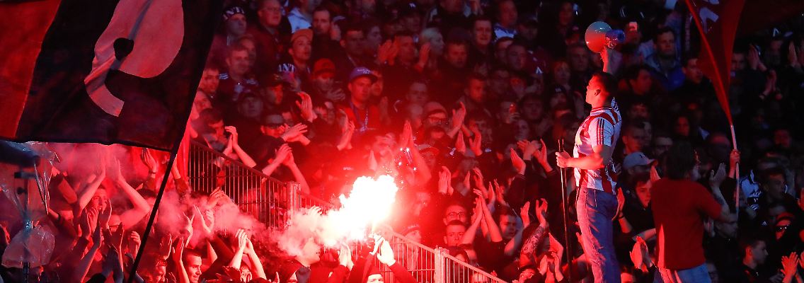 Die Stimmung im Stadion ist angespannt - auf beiden Seiten werden Bengalos gezündet.