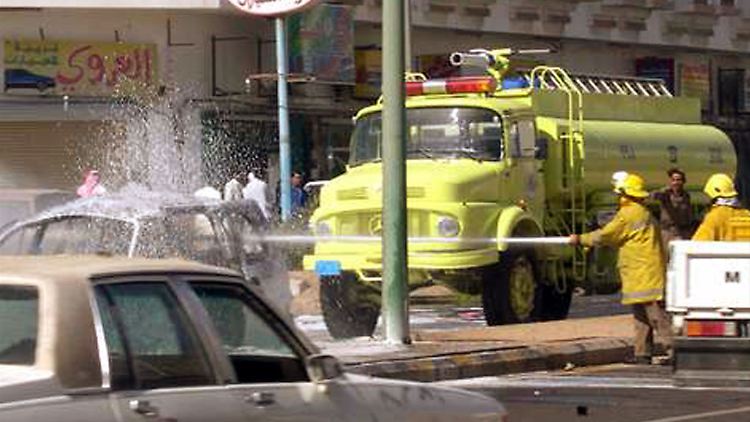 Feuerwehrleute löschen einen Brand nach dem Anschlag 2004 in Janbu.