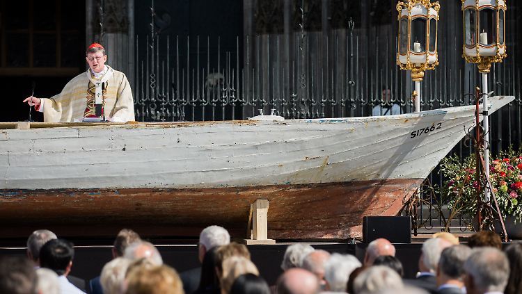 Ein Flüchtlingsboot dient an Fonleichman als Altar: Der Kölner Erzbischof Woelki weist auf die Not von Flüchtlingen hin.