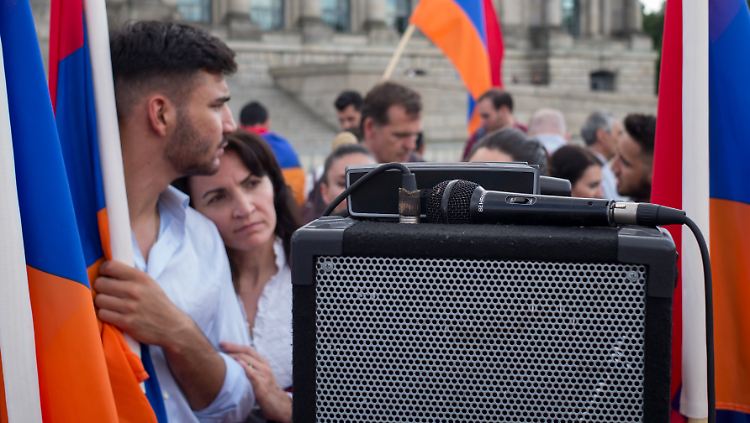 Über einen Lautsprecher kann Anna Hanesyan aus Hannover hören, was im Bundestag gesagt wird. Sie ist mit ihrer Familie nach Berlin gekommen, um diesen "entscheidenden Moment" auf dem Platz der Republik erleben zu können.