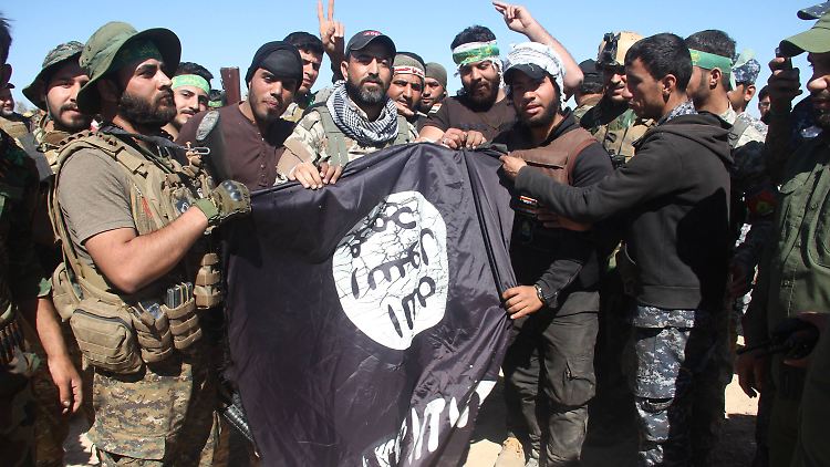 Irakische Soldaten mit einer erbeuteten IS-Flagge. 