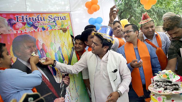 Sie meinen es nett: Hindu-Nationalisten schmieren Trump Kuchen auf den Mund.
