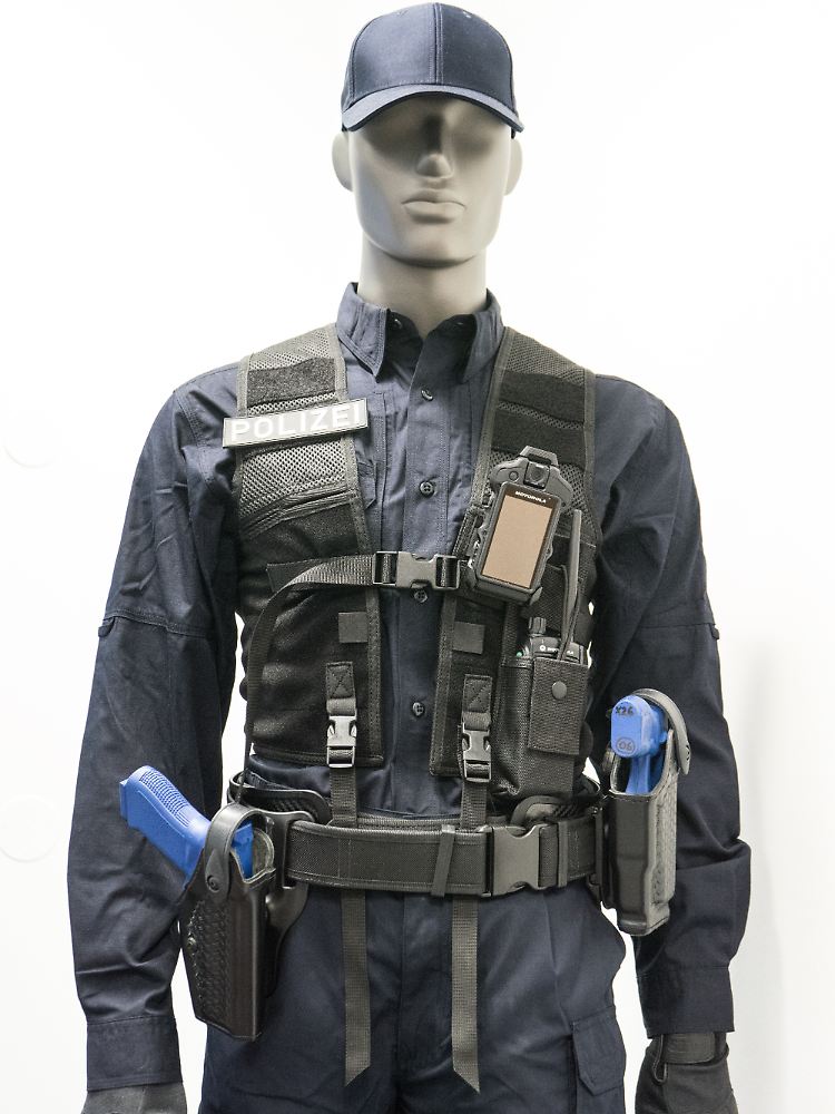 Der Beamte trägt an der linken Brust ein Motorola-Funkgerät mit Kamera. Zieht man die Pistole, startet sie die Aufzeichnung und in der Leitstelle wird die Position des Polizisten angezeigt.