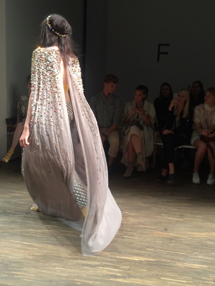 Fließende Stoffe werden durch markante Details ergänzt und Swarovski-Kristalle verleihen ein edles, dezent-glamouröses Finish.