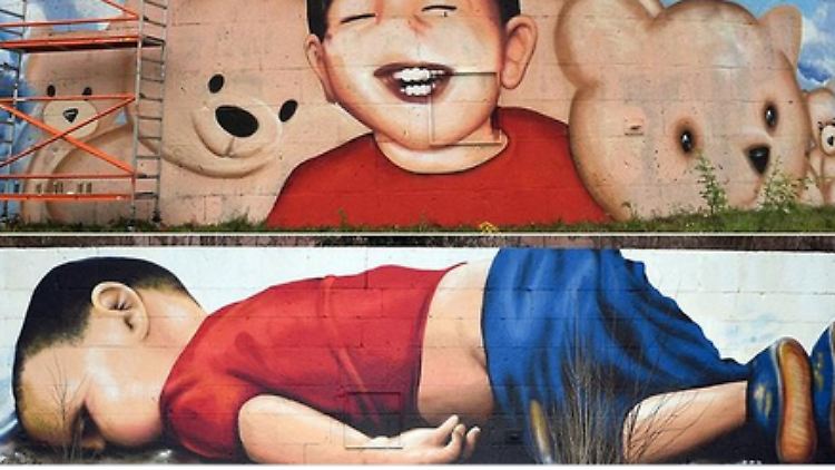 Die Graffiti-Künstler Ohuz Sen und Justus Becker lassen den Flüchtlingsjungen Aylan auf ihrem neuen Wand-Gemälde lachen.