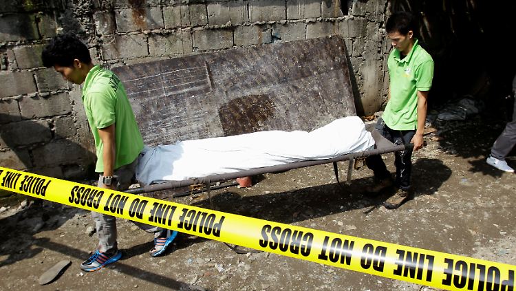 Bestatter transportieren den Körper eines mutmaßlichen Drogendealers ab, der am Sonntag von der Polizei in Manila getötet worden war.