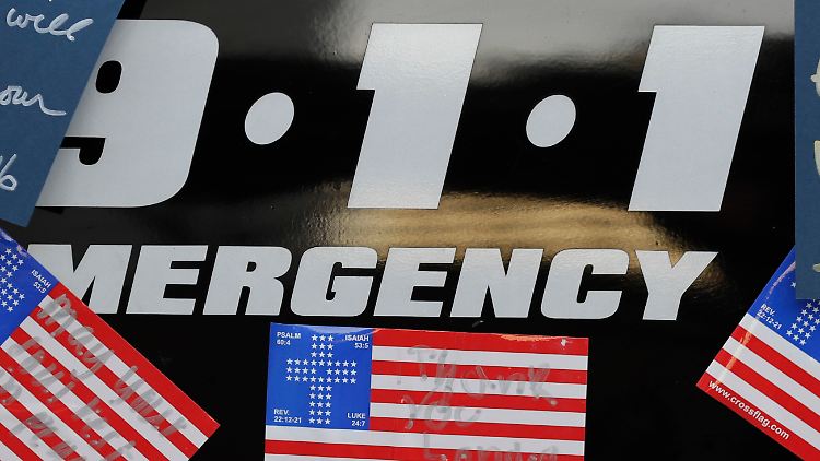 In Dallas heften Menschen Beileidsschreiben an ein Polizeiauto.