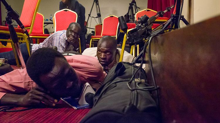 Als Schüsse auf den Präsidentenpalast in Juba abgefeuert werden, liegen Journalisten auf dem Boden eines Presseraumes.