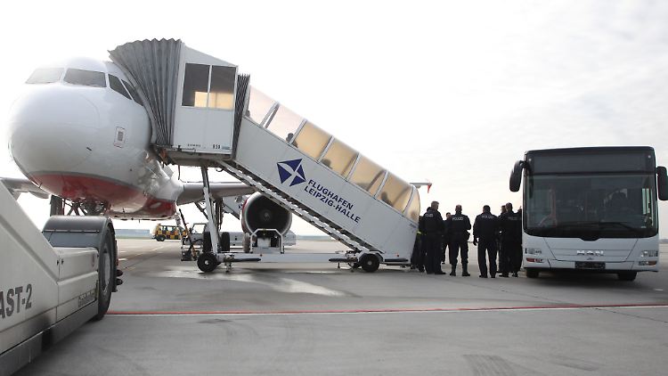 Polizisten überwachen die Ankunft abgelehnter Asylbewerber auf dem Flughafen Leipzig-Halle.