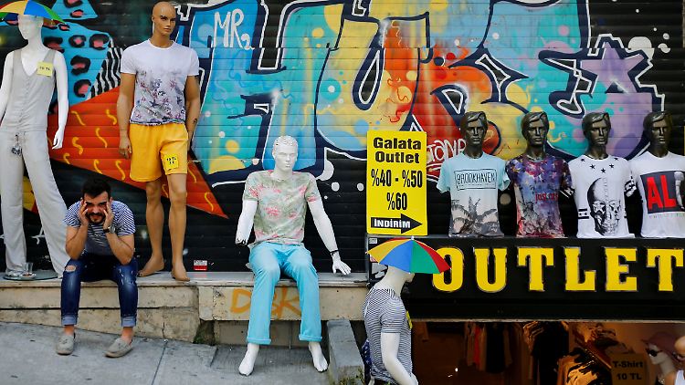 Ein Mann sitzt vor einem Outlet-Store in Istanbul - die politische Unsicherheit wird auch die Wirtschaft treffen.