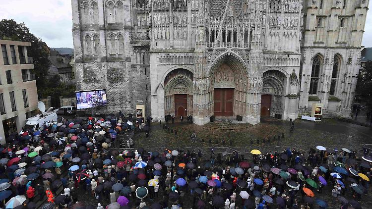 Eine Großbildleinwand überträgt die Zeremonie aus dem Kircheninneren.
