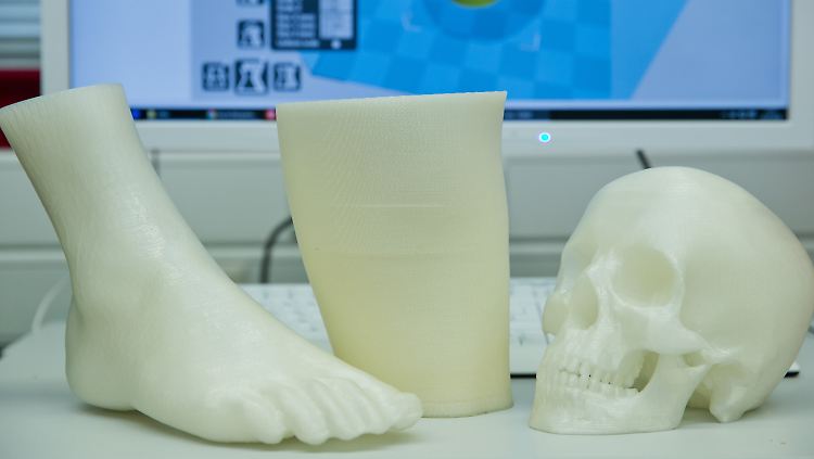 Ein Fuß, eine Beinprothesen-Entwurf und ein menschlicher Schädel, alles 3D-Drucke, an der Universität Erlangen-Nürnberg.