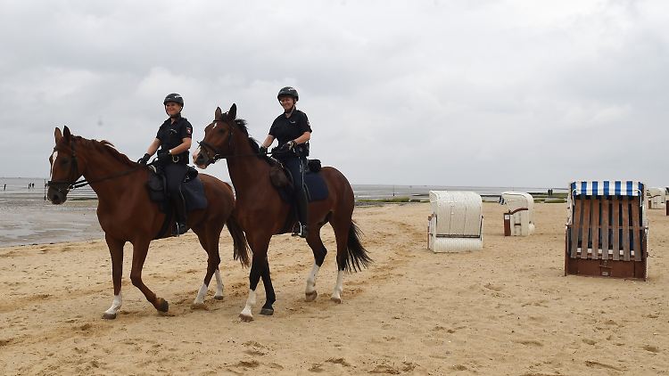 Die Polizeikommissarinnen Carolin Dietz (l) auf Goya und Andrea Neumann auf Jogo reiten am Strand von Cuxhaven-Sahlenburg. In der Sommersaison verstärken sie die Polizei in Cuxhaven. Sie sind vor allem im Watt im Einsatz.