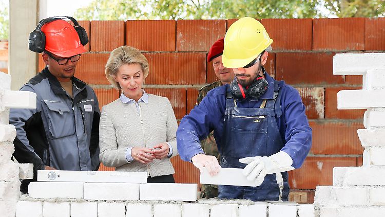 Am ersten Tag der Flüchtlingsvorausbildung bei der Bundeswehr guckt Verteidigungsministerin Ursula von der Leyen den neuen Auszubildenden über die Schulter.