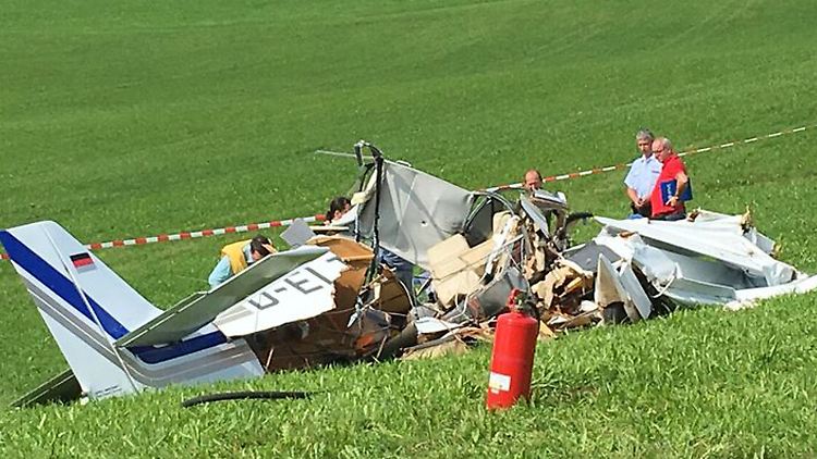 Experten untersuchen das völlig zerstörte Flugzeugwrack. 