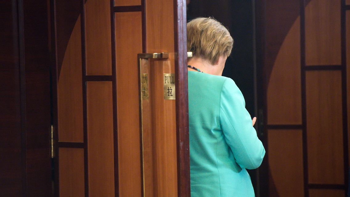 Wirft die Bundeskanzlerin hier einen raschen Blick auf die ersten Hochrechnungen?