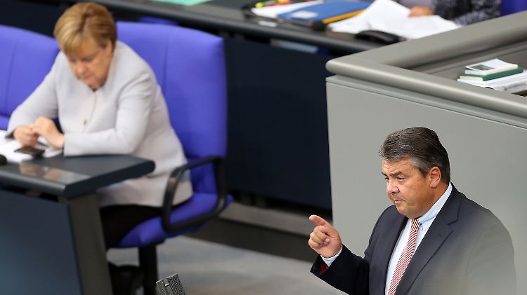 Der Vizekanzler und seine Kanzlerin: Gabriel bei seiner Rede, Merkel hört zu.