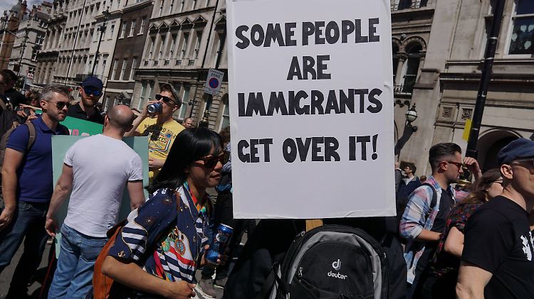 Auf einer Protestkundgebung verlangen die Demonstranten: "Manche Menschen sind Migranten. Kommt drüber hinweg!"