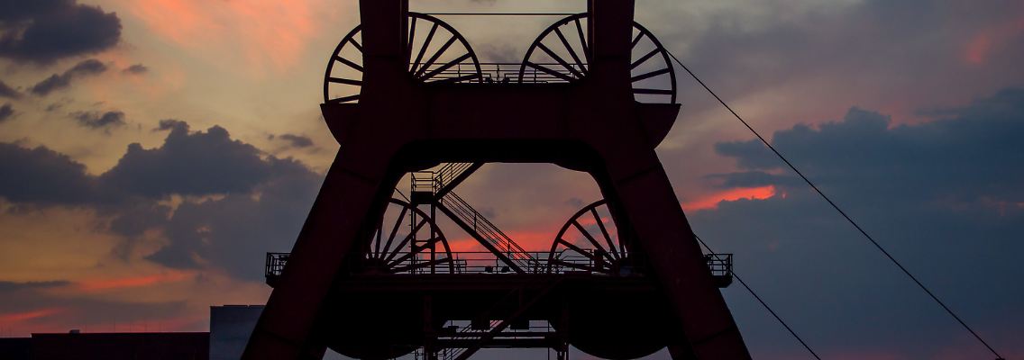 Die Sonne geht hinter der Zeche Zollverein in Essen unter.