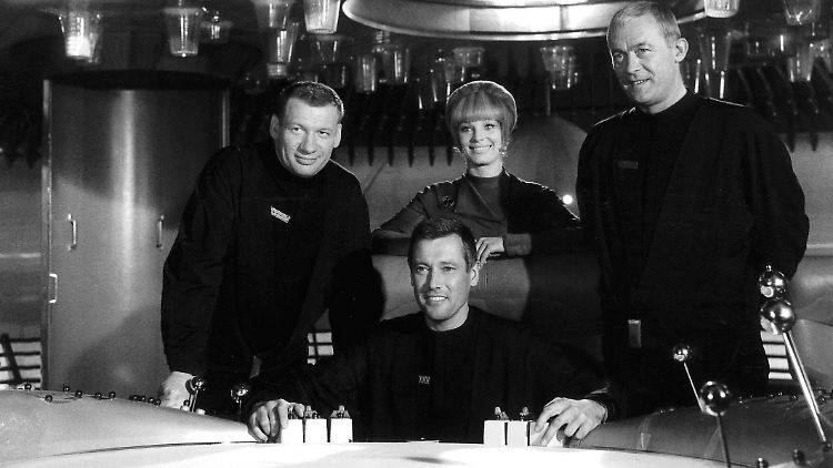 Die Szene aus dem Science-Fiction-Klassiker zeigt (v.l.) Leutnant Mario de Monti (Wolfgang Völz), Major Cliff Allister McLane (Dietmar Schoenherr), Leutnant Tamara Jagellovsk (Eva Pflug) und Leutnant Hasso Sigbjoernson (Claus Holm).