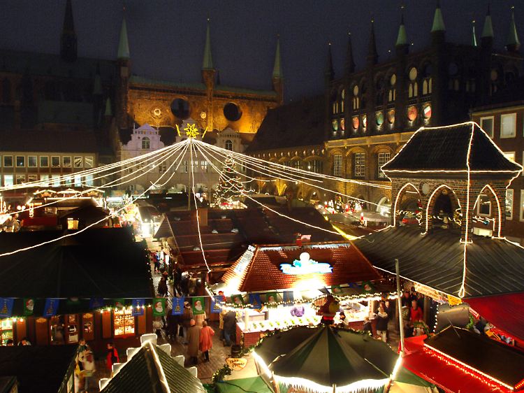 Der Lübecker Weihnachtsmarkt erstrahlt vor dem Rathaus im weihnachtlichen Lichterglanz.