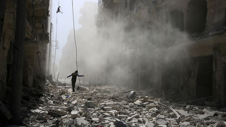 Ein Mann wandert über die Ruinen von Aleppo.
