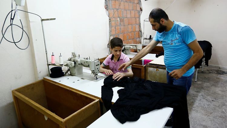 Ein Syrer erklärt seinem Sohn in der Türkei das Handwerk.