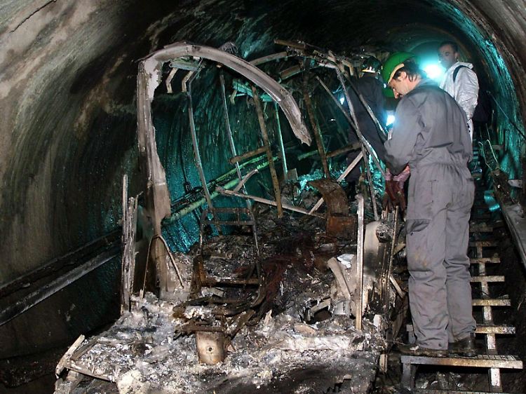 Bergungsarbeiter inspizieren die Überreste der verbrannten Tunnel-Gletscherbahn am Kitzsteinhorn bei Kaprun.