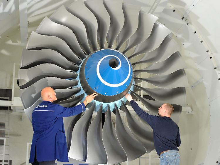 Zwei Rolls-Royce-Techniker überprüfen im Mechanical Test Operation Centre (MTOC) im barndenburgischen Dahlewitz eine Triebswerksschaufel in einer Vakuumkammer.