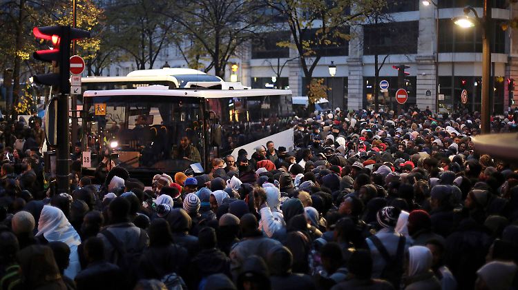 Flüchtlinge warten darauf, in die Busse zu kommen.