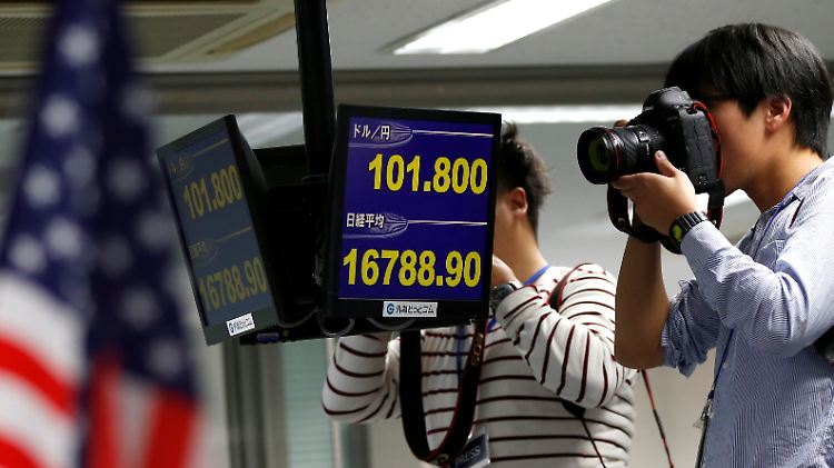 Historische Kursreaktionen: In Tokio halten Pressefotografen die Notierungen von Yen und Dollar im Bild fest.